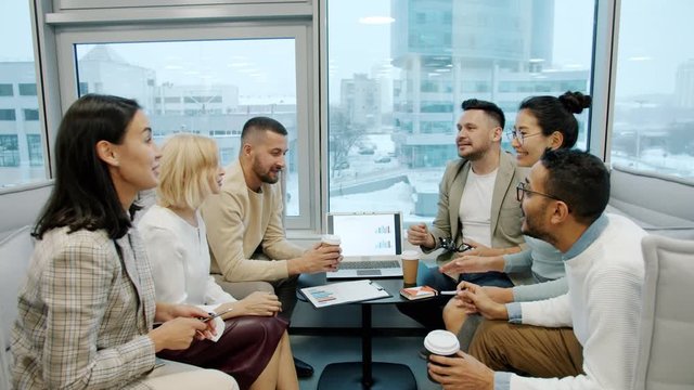 Happy coworkers male and female are sharing ideas brainstorming then doing high-five in modern office. Communication, business and people concept.