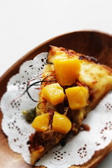 Piece of tropical fruit mango and beef Pizza on wooden plate