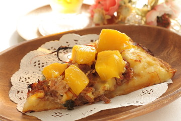 Piece of tropical fruit mango and beef Pizza on wooden plate