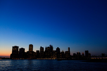 Fototapeta na wymiar Manhattan: Shadow Lower Manhattan through East River from Brooklyn