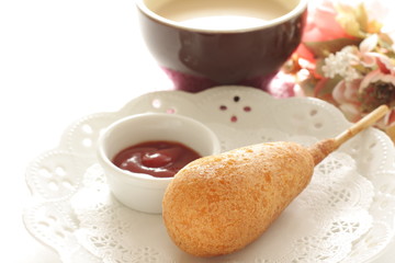 Corn dog and ketchup on dish for fast food