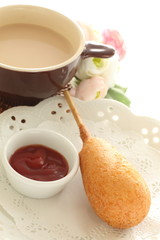 Corn dog and ketchup on dish for fast food