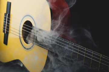Obraz na płótnie Canvas Guitar in smoke close up. musical instrument. strings on the guitar neck