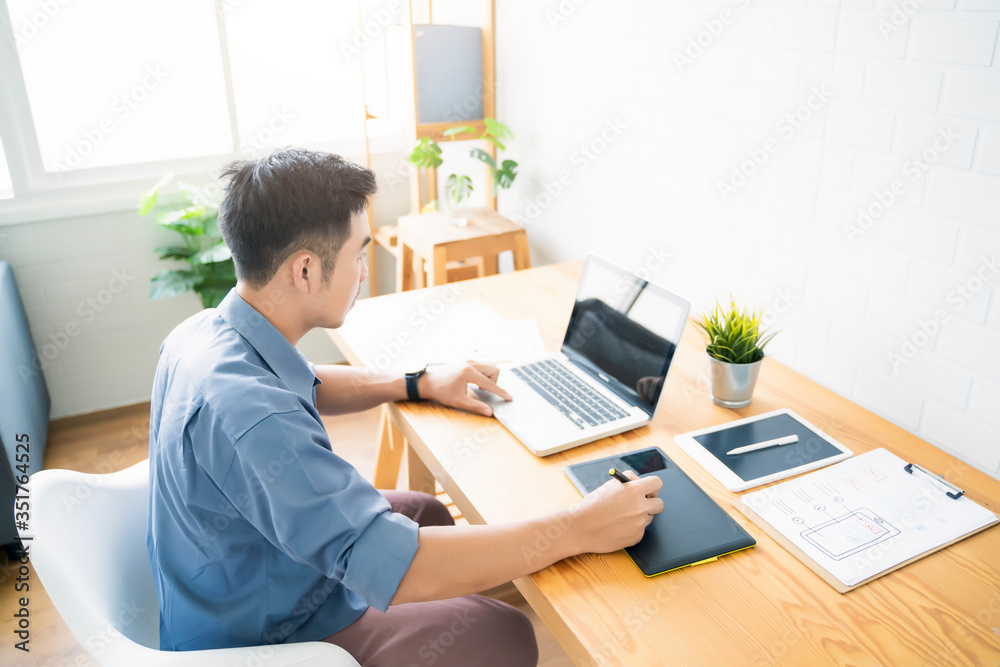 Fototapete Working from home web designing graphical user interface UX UI, home office using computer laptop and pen sketching graphics tablet device creative planning innovative ideas, asian man quarantine