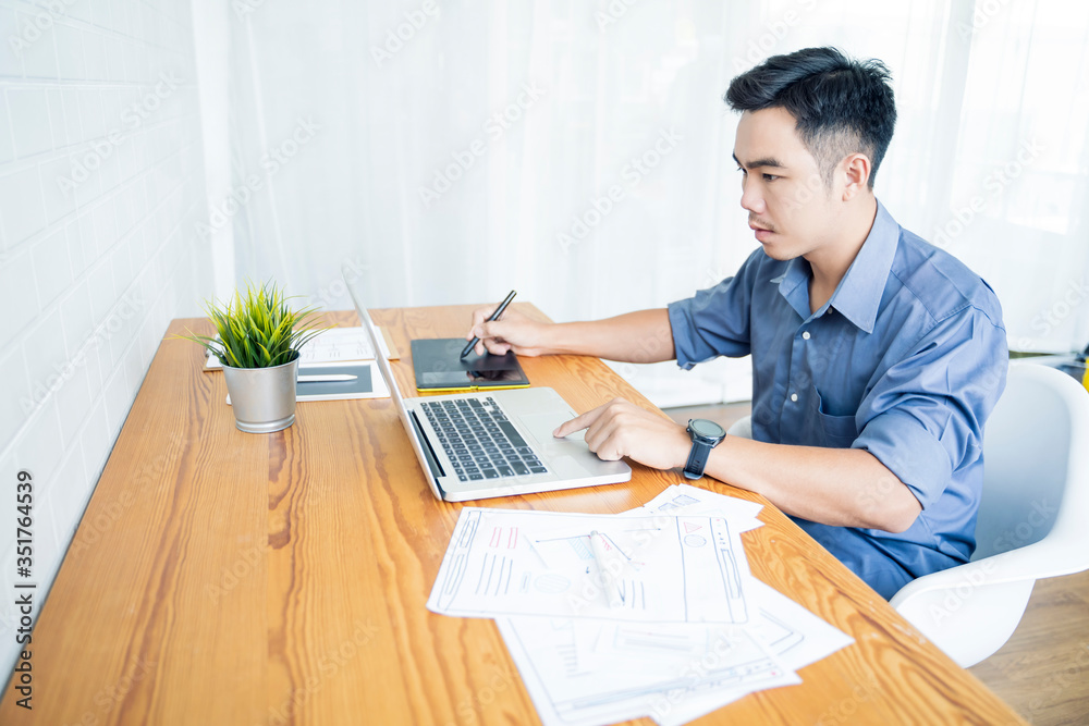 Fototapete Working from home web designing graphical user interface UX UI, home office using computer laptop and pen sketching graphics tablet device creative planning innovative ideas, asian man quarantine