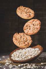 Fototapeta premium oatmeal cookies floating on wooden background, close-up