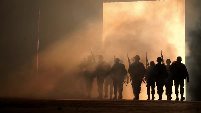 group of soldiers walk through smoke , slow motion.