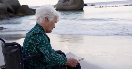Woman reading a book on the beach