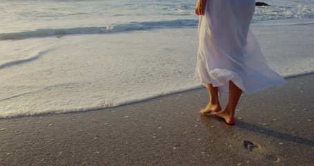 Woman walking on beach during sunset