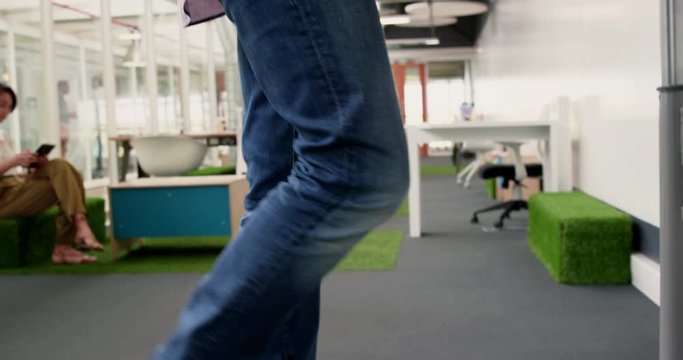 Businessman exercising on treadmill while talking on mobile phone in m