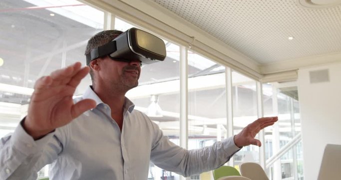 Businessman using virtual reality headset at desk in modern office 4