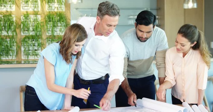 Business people working on blueprint at table in a modern office