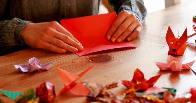 Woman preparing origami with paper at home