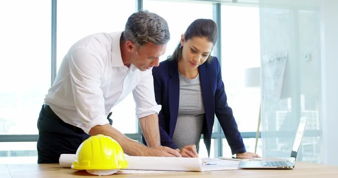 Architects working together on blueprint in a modern office