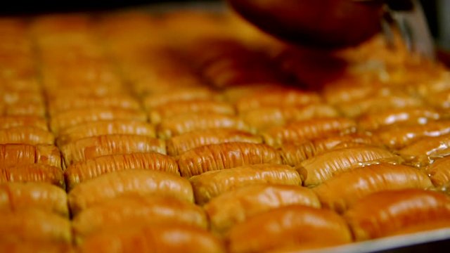 man pours sugar water on baklava and starts bubbling baklava
