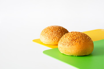 Two round sandwich buns with sesame seeds isolated on white background