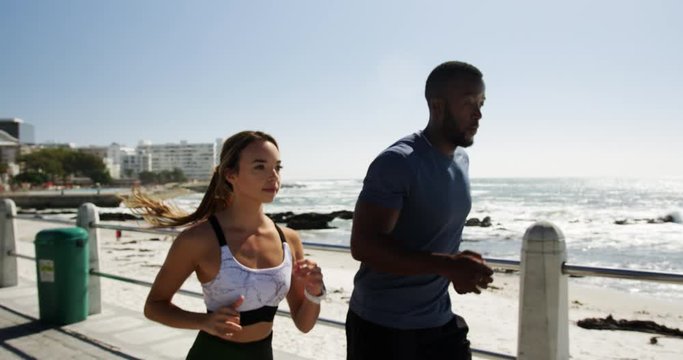Fit Couple jogging on a promenade at beach