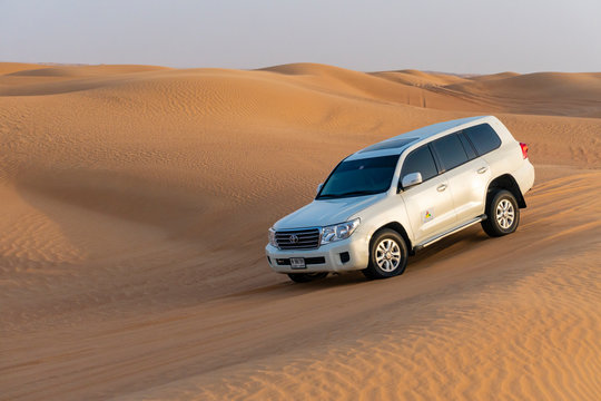Dubai, UAE - Oct 10, 2018: Toyota Landcruiser 4WD driving through dunes, also called dune bashing as part of a desert safari in Dubai