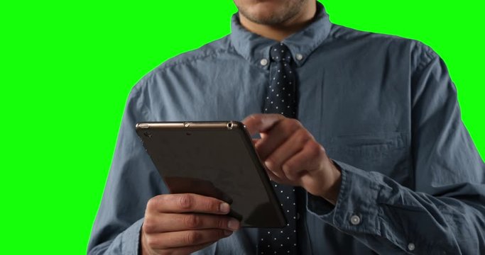 man using a digital tablet on green background