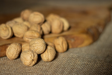 walnuts over jute fabric and a wooden cutting board