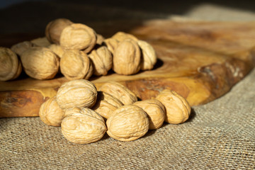 walnuts over jute fabric and a wooden cutting board