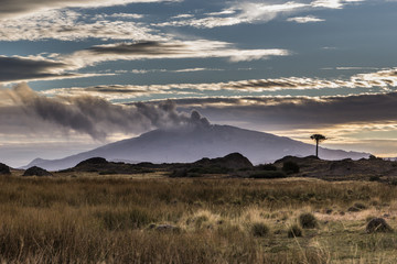 the smoke of a volcano in the sunset