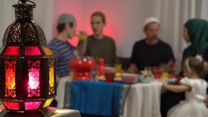 Islamic holiday of Eid al-Fitr, which marks the end of Ramadan. Festival of Breaking the Fast. Authentic Muslims family around the table break their fast with dates
