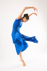 Adult woman dancing in the studio in a blue dress.