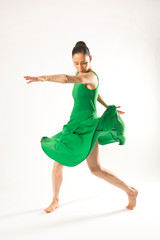 Adult woman dancing in the studio in a green dress.
