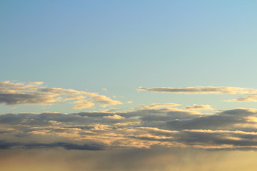 White fluffy clouds on a background of blue sky in summer. The concept of weather and climate.
