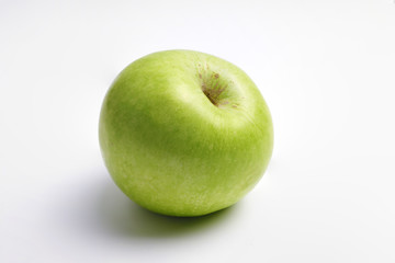 One fresh green apple on a white background