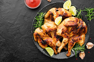 Spatchcocked barbecue chicken for family dinner on black background top view