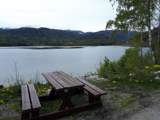Obraz premium Wooden bench on the shores of the blue fjord