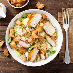 Classic caesar salad with grilled chicken fillet and parmesan cheese. top view