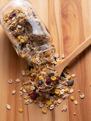 Granola and glass containers set against a wooden background