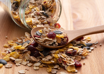 Granola and glass containers set against a wooden background