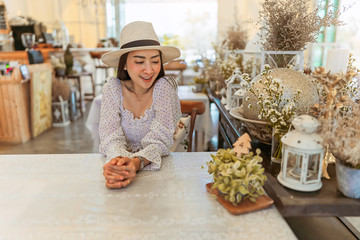 Portrait of stylish young woman in dress vintage style and hat sit posing in the coffee shop decoration in vintage style