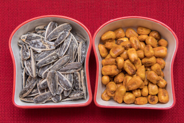 mixed nuts plate on red background. Seed, sauce corn and mixed nuts