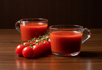 Tomato juice and tomatoes set against a wooden backdrop