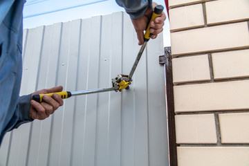 A worker installs a metal profile fence.