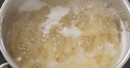 boiling fusilli pasta in saucepan closeup