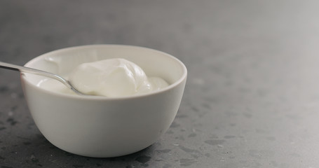 scoops yogurt from white bowl with copy space