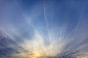 Traces of airplanes on a blue sky at sunset