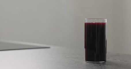 blueberry juice in highball glass on kitchen countertop