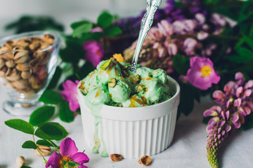 pistachio green ice cream in a white bowl with a spoon on the table