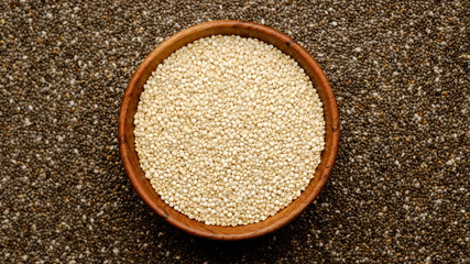 quinoa seeds in wooden bowl and chia seeds background. top view 