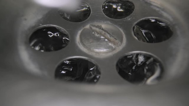 Water flowing down the drain, macro shot with prob lens