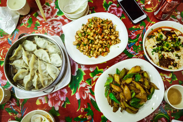 Shanghai - Apr 30, 2017:  Traditional dinner in chinese cantine: chinese dumplings, food and vegetables.