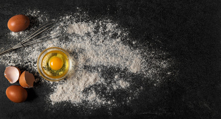 Baking ingredients eggs flour dark background Dough preparation