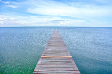 View of a wooden bridge stretching down to the sea